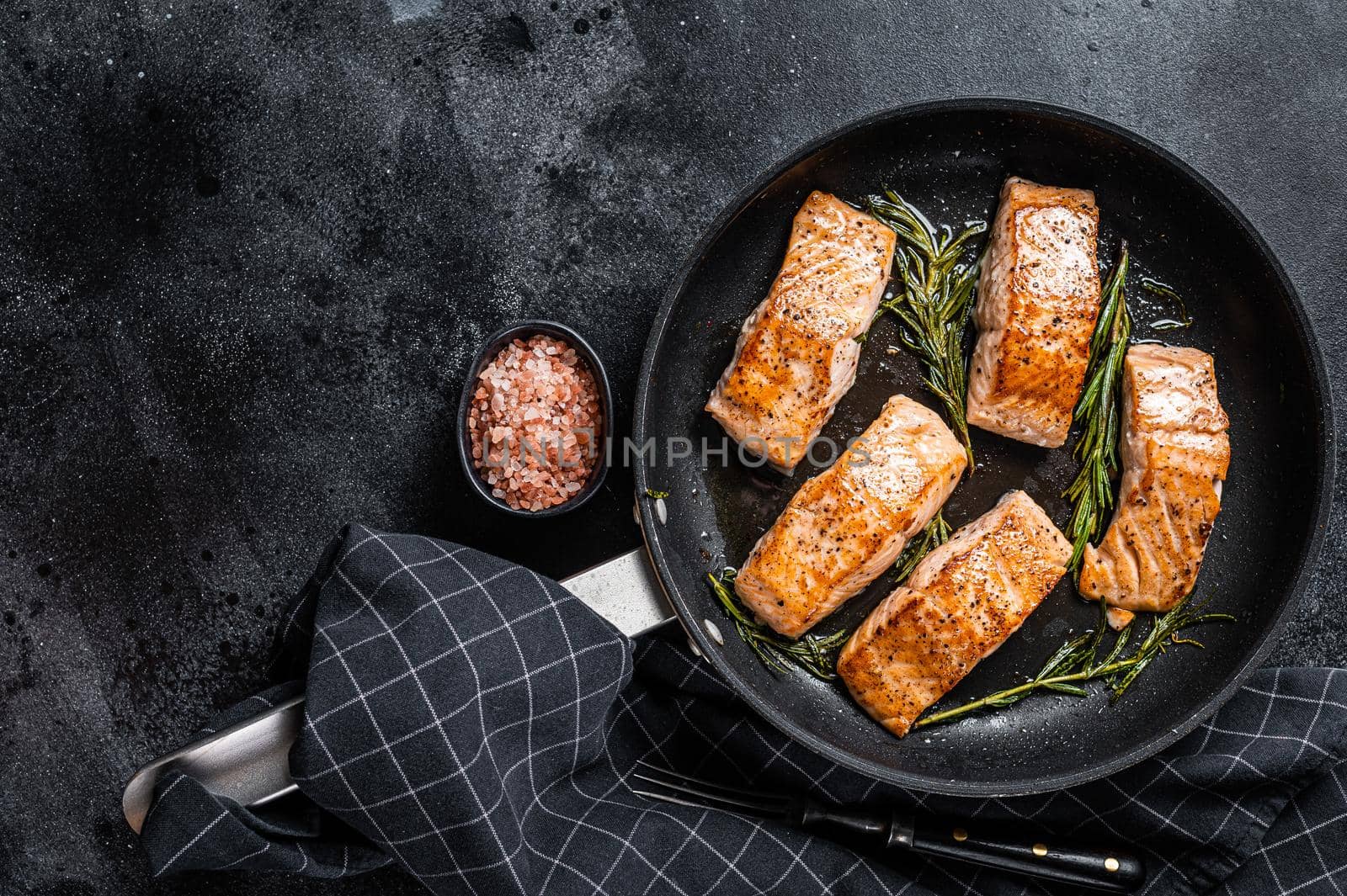 Grilled Salmon Fillet Steak in a pan. Black background. Top view. Copy space.