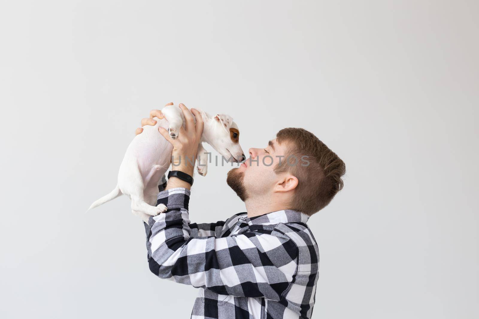 people, pets and dogs concept - young man hugging funny puppy on white background by Satura86