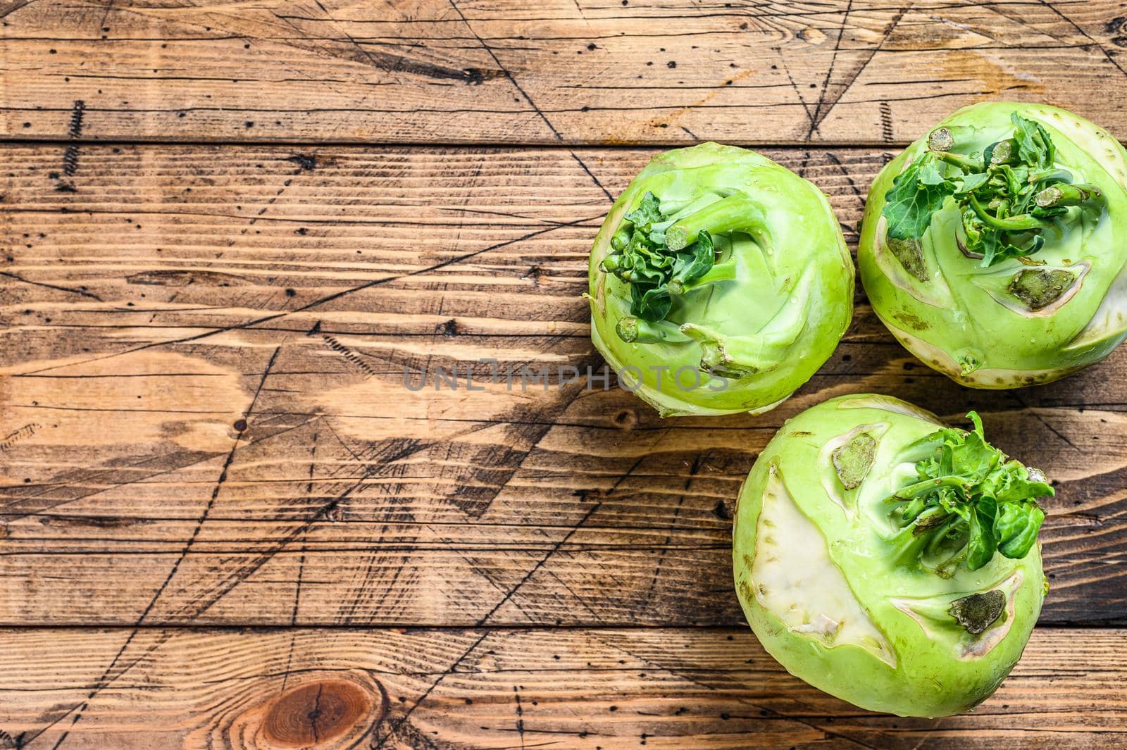 Heads of fresh ripe white cabbage kohlrabi. Wooden background. Top view. Copy space.