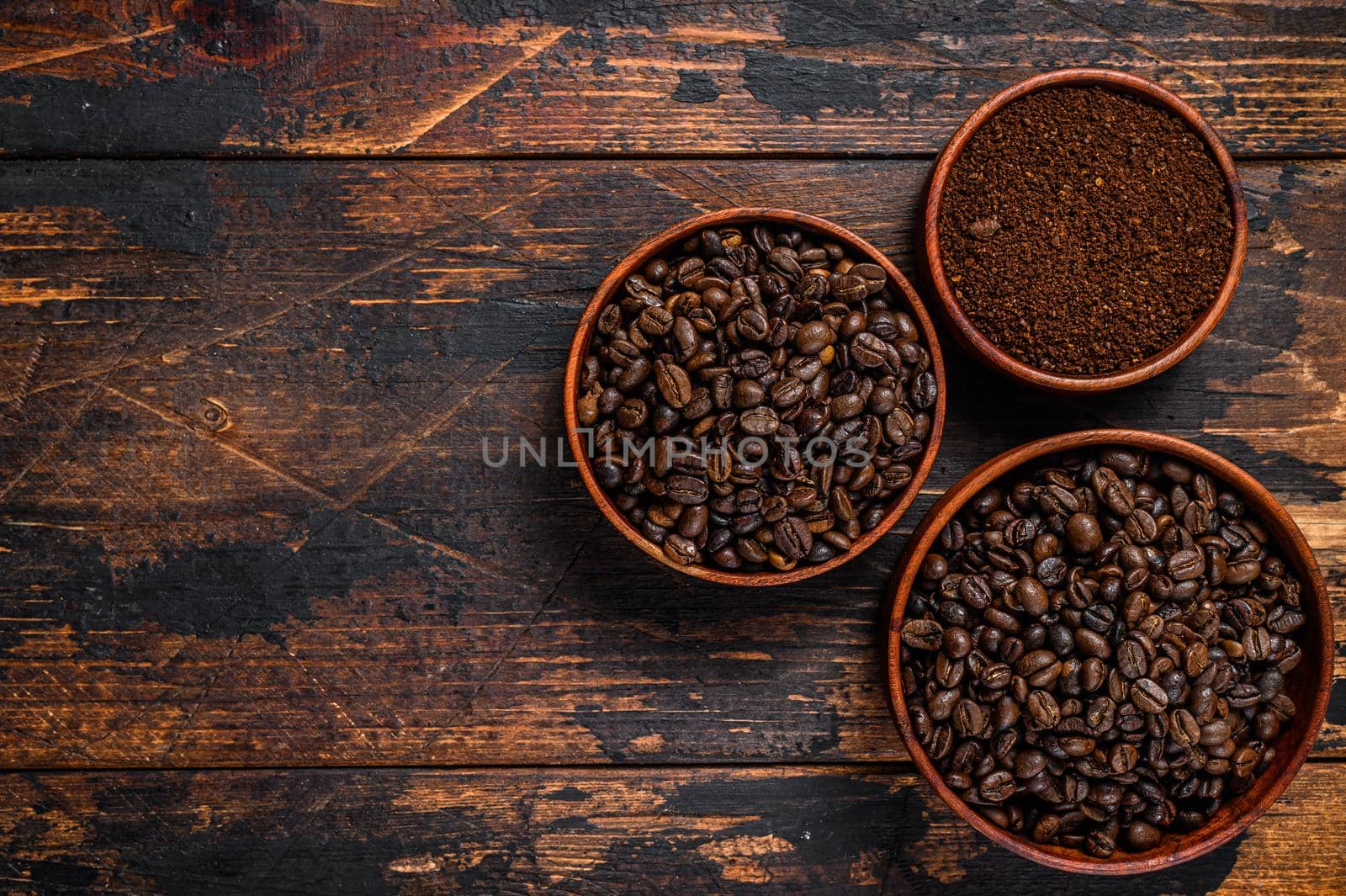 Background of coffee beans and grinded ground coffee. Dark wooden background. Top view. Copy space by Composter