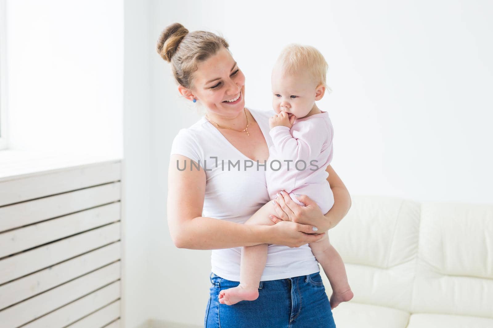 Childhood, family and motherhood concept - Mother holding sweet baby girl.