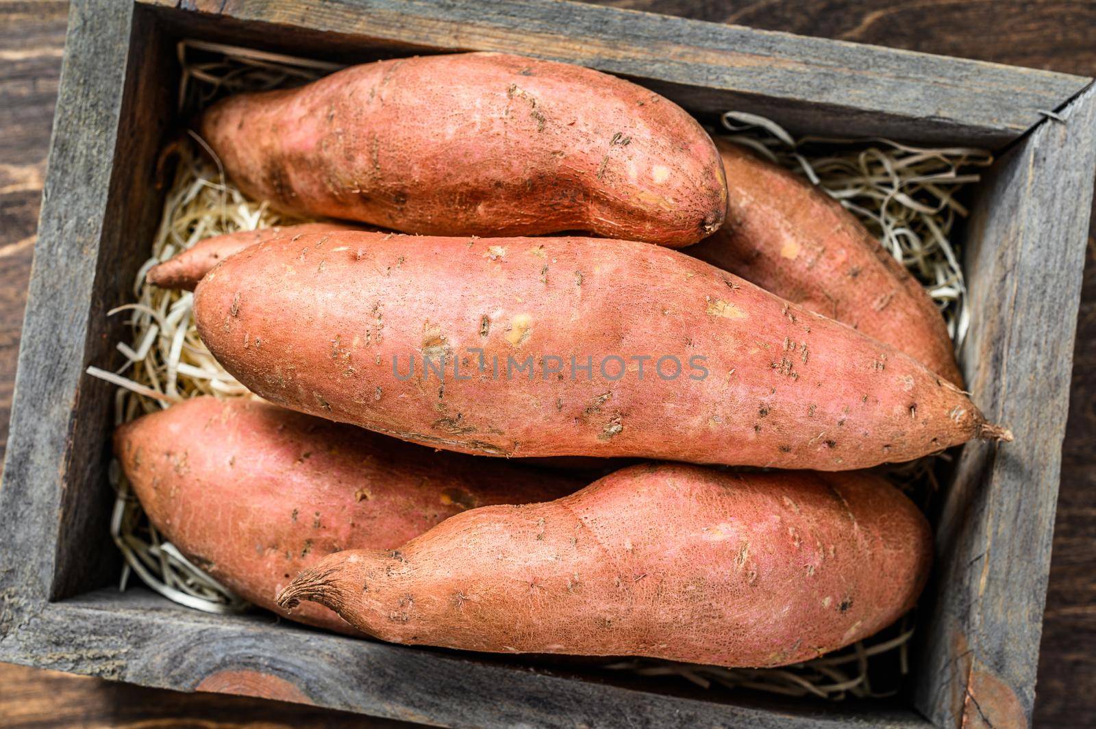 Raw batata Sweet potato on Wooden table. Wooden background. Top view by Composter