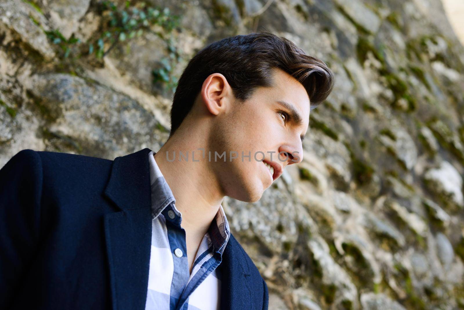 Portrait of handsome man with modern hairstyle in urban background