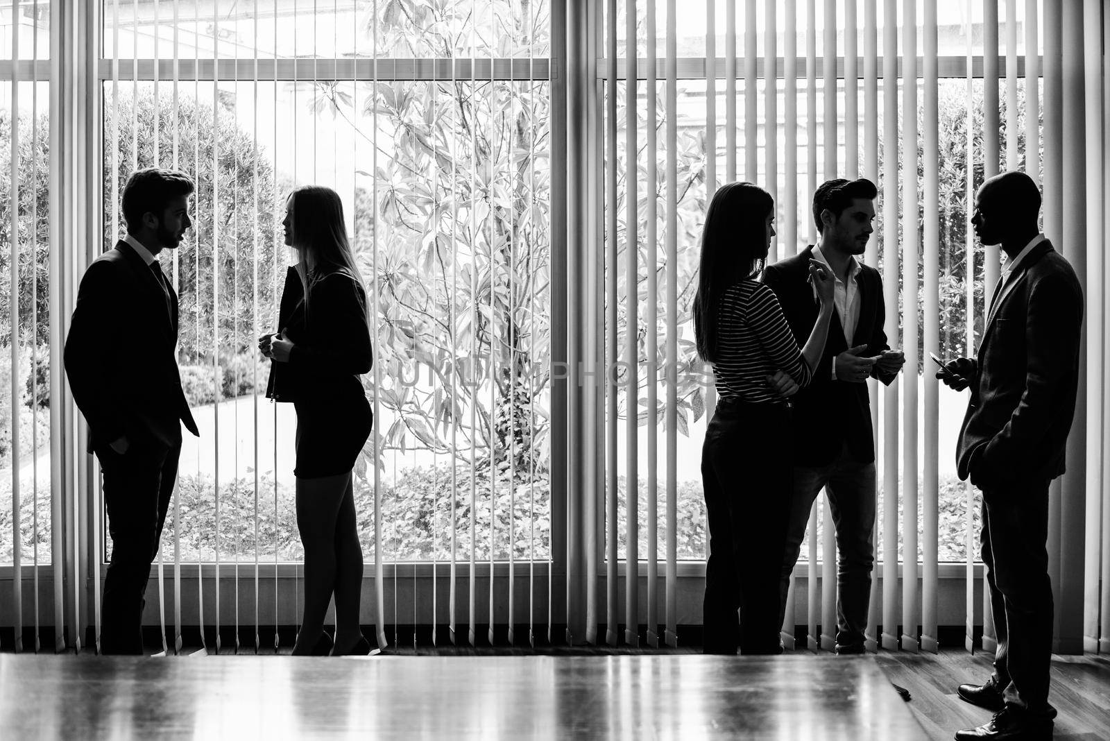 Silhouettes of businesspeople interacting background business centrer by javiindy