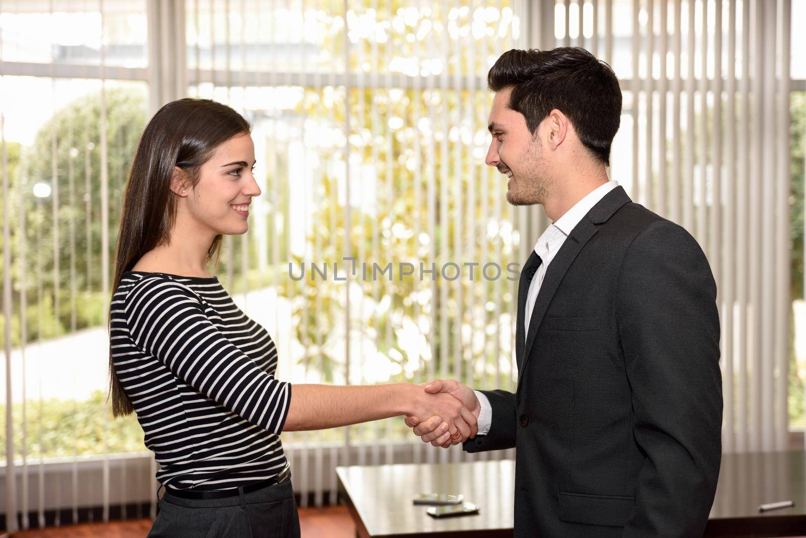 businesswoman and businessman shaking hands, finishing up a meeting