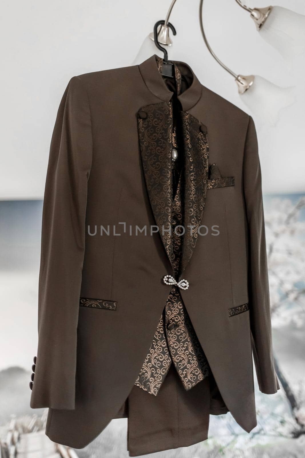 Luxury stylish brown men's suit with patterns and diamond clasp.