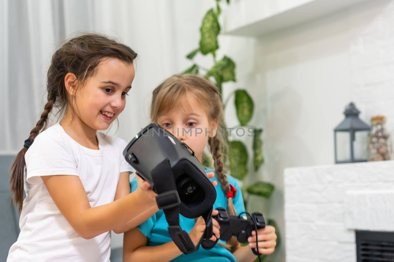 two little girls using glasses of virtual reality headset. concept of modern technologies by Andelov13