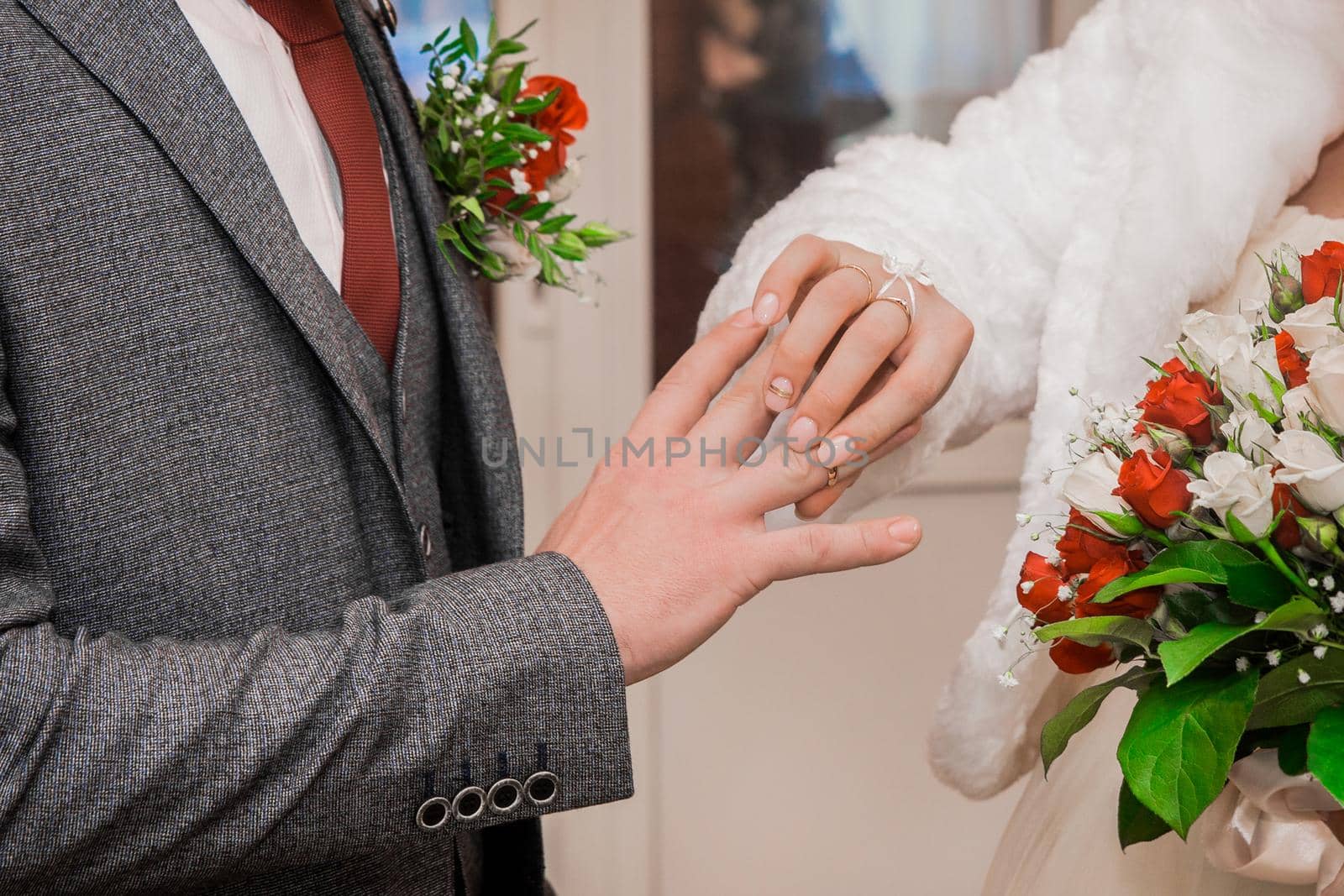 Bride's hand puts wedding ring on groom's thumbs up by AYDO8