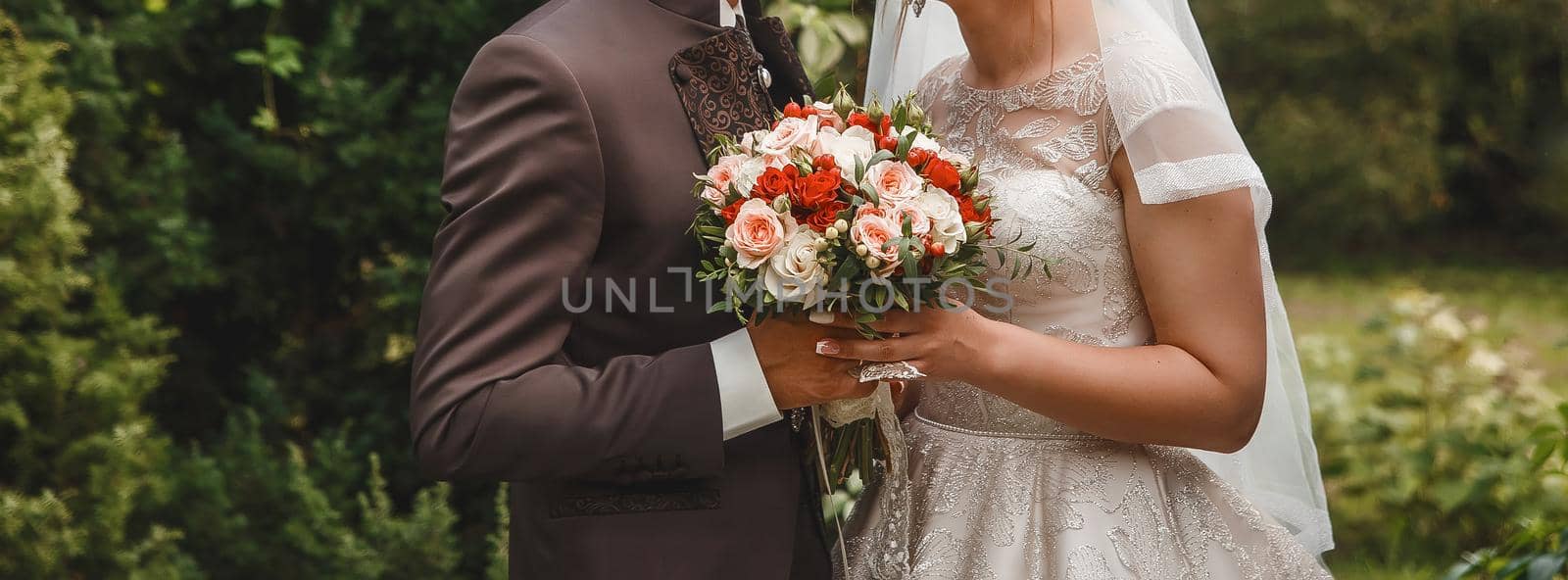 The bride and groom hold together with their hands a wedding bouquet of flowers by AYDO8