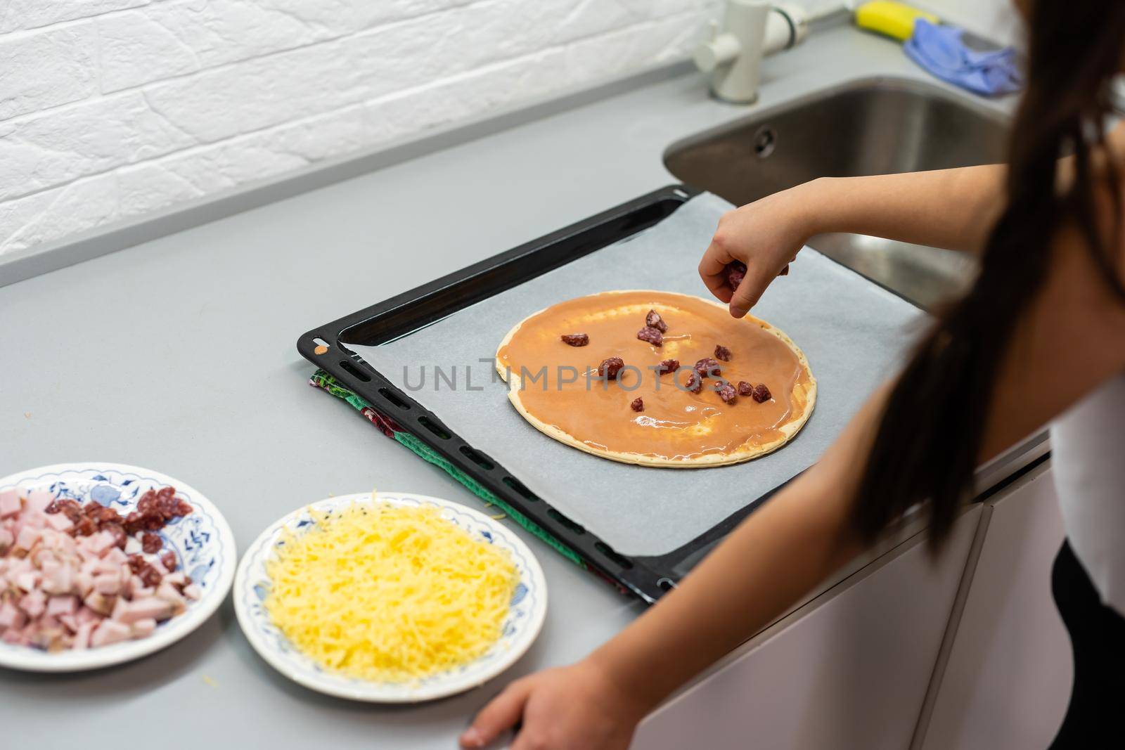 little girl makes pizza at home