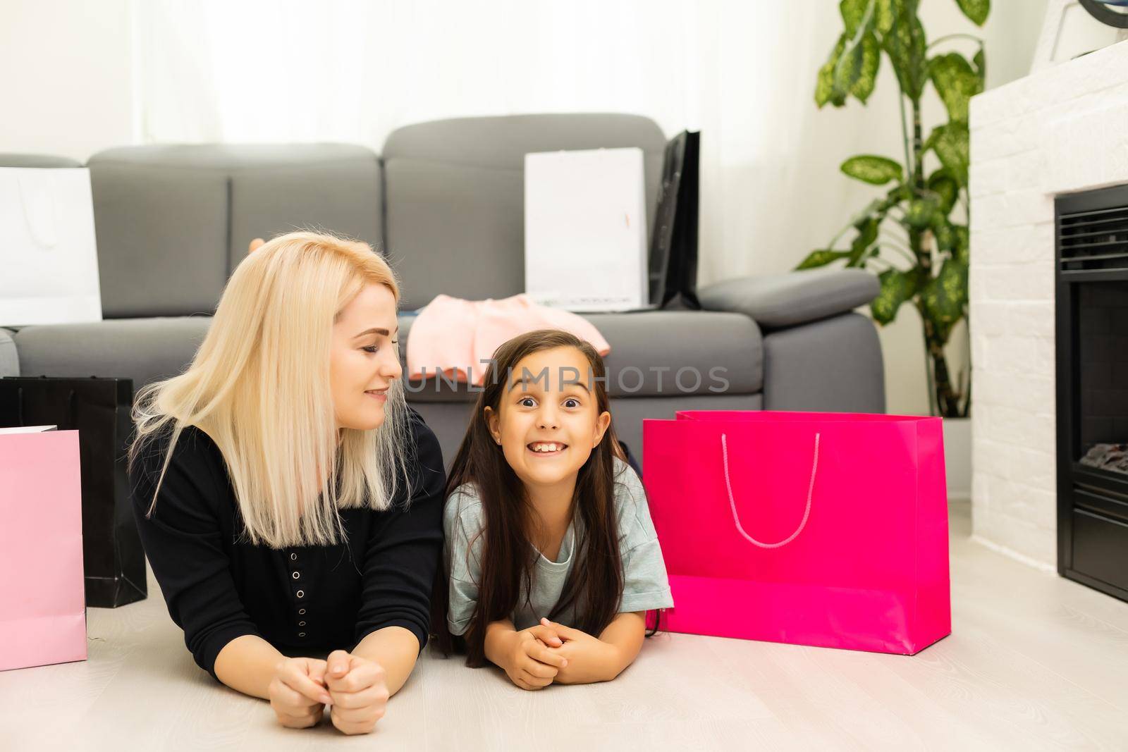 Jolly mother and her daughter having fun at home after shopping