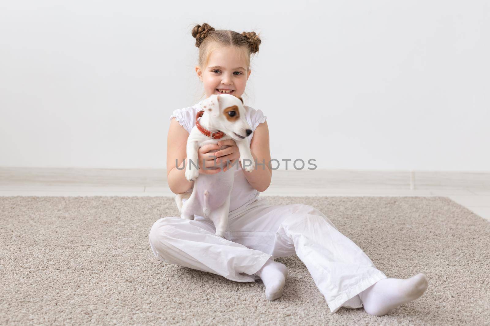 Dogs, children and pets concept - little child girl sitting on the floor with cute puppy by Satura86