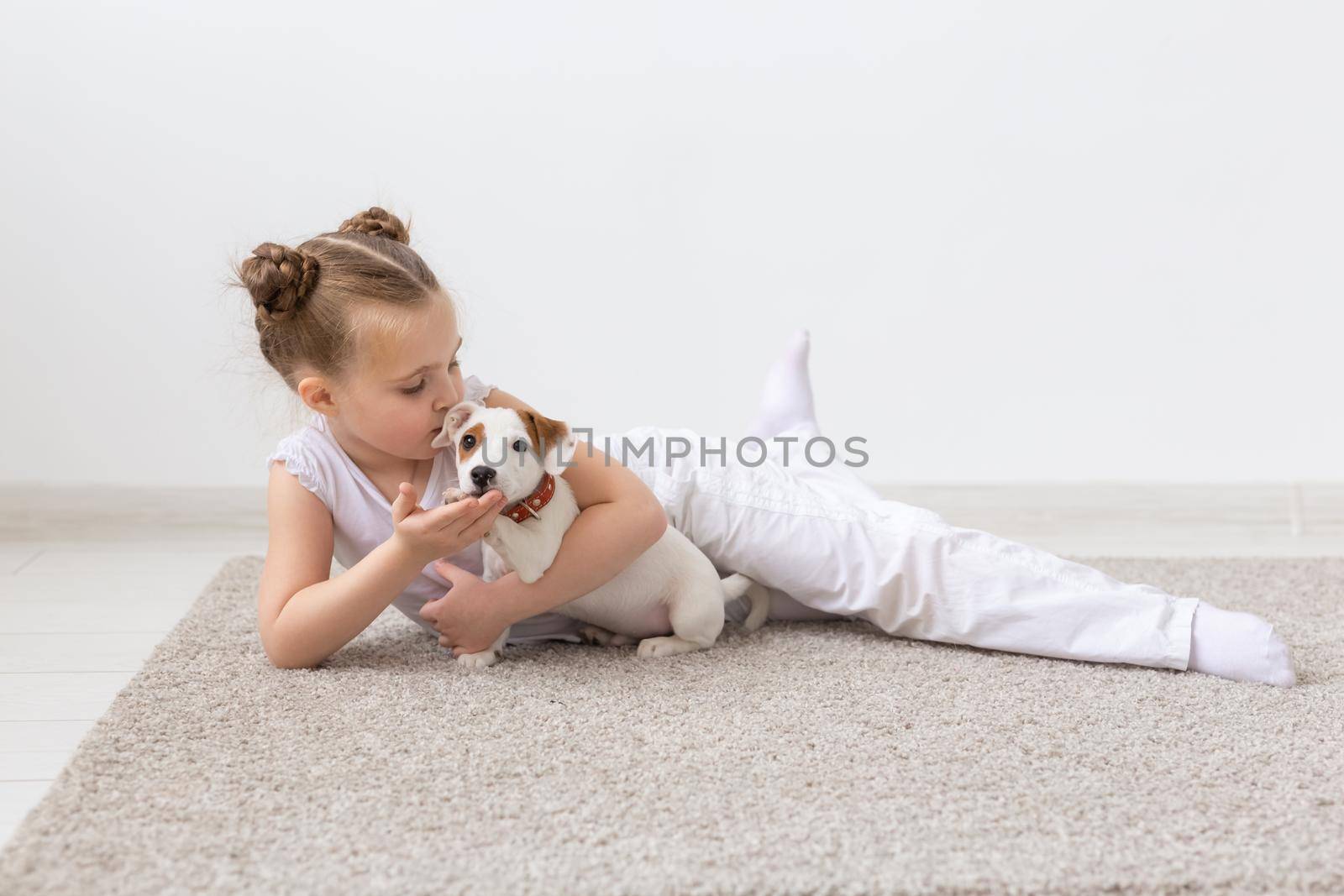 Childhood, pets and dogs concept - Little child girl posing on the floor with puppy by Satura86
