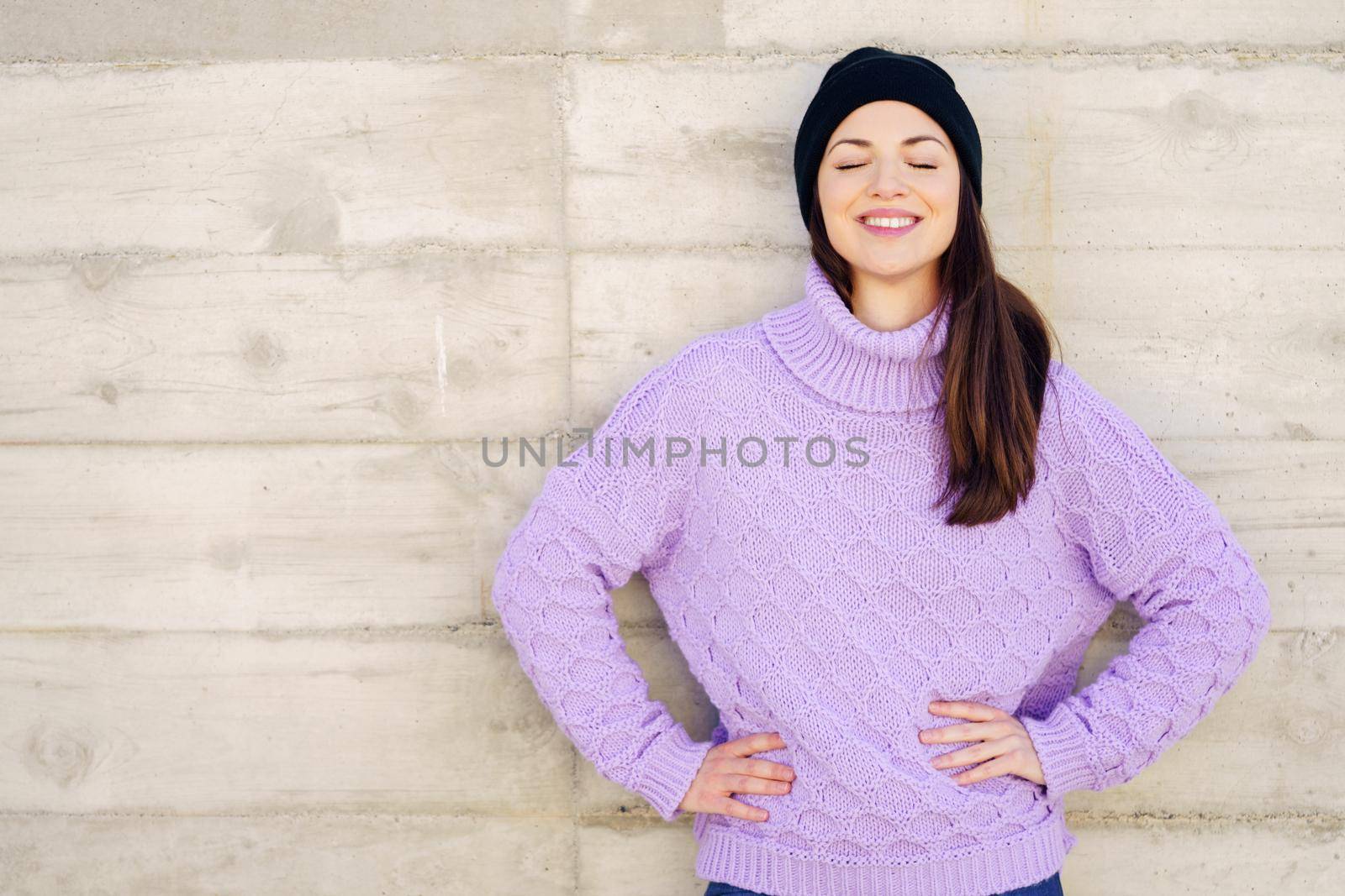 Happy young woman smiling with eyes closed outdoors. Lifestyle concept.