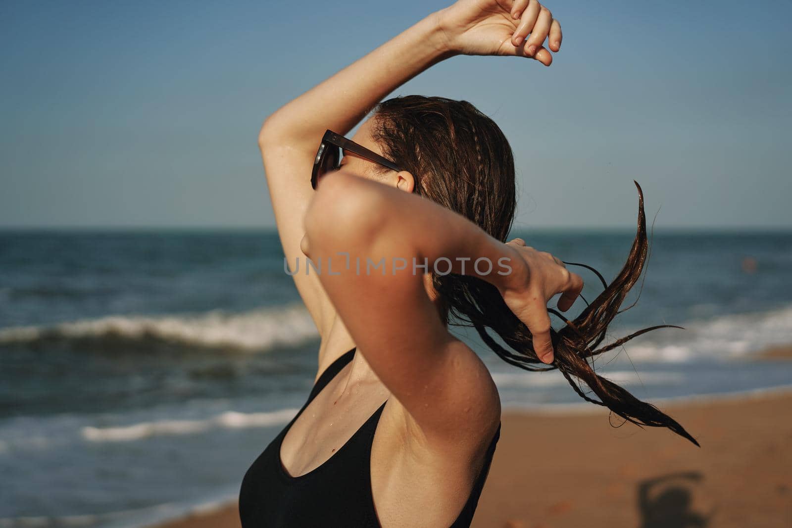 cheerful woman in black swimsuit sunglasses beach walk travel. High quality photo