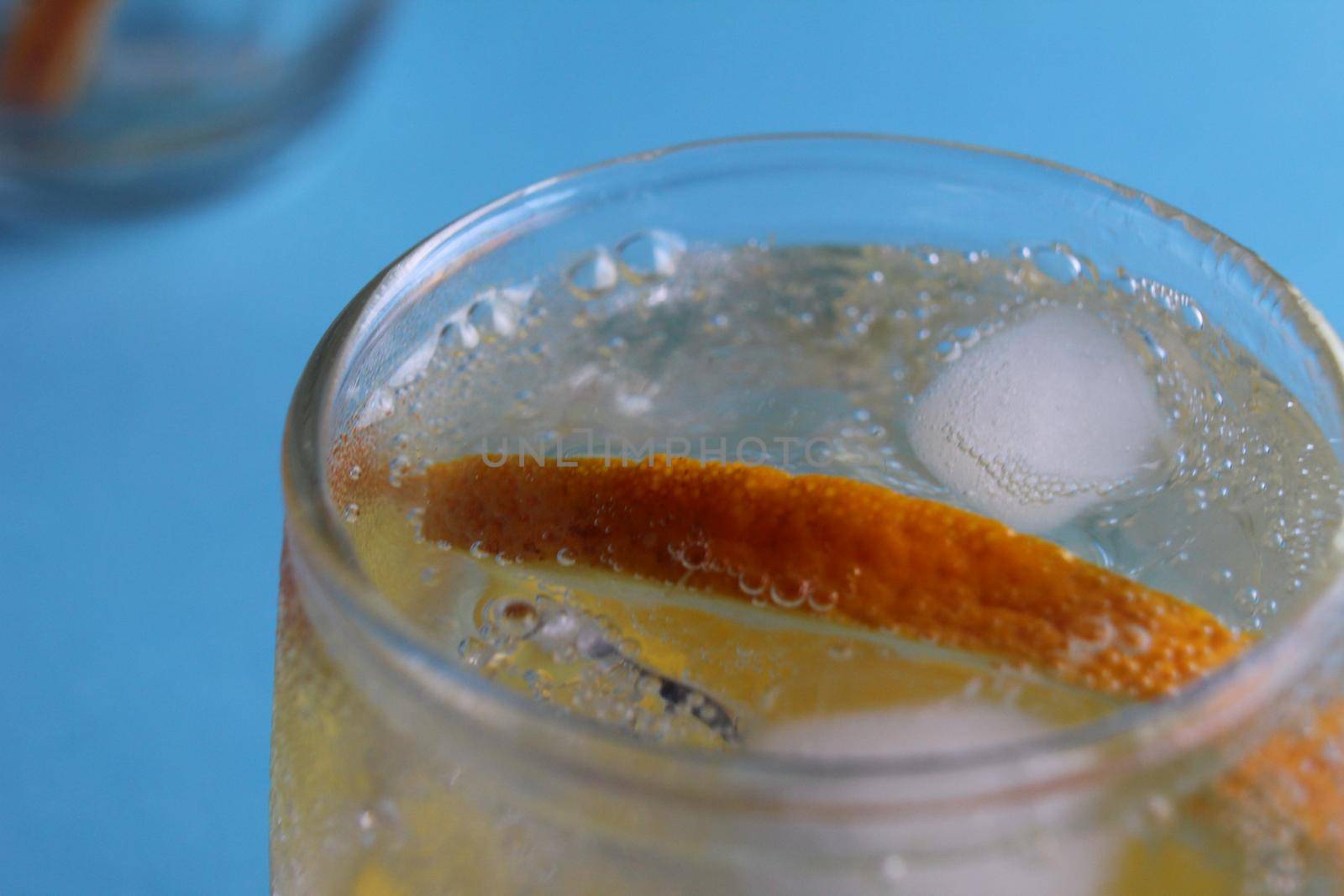 Step-by-step instruction of making lemonade. Step 3. Ready-made fresh lemonade with water ice and fruit close-up view from above on a blue background. Summer refreshing drinks. Heat remedy.