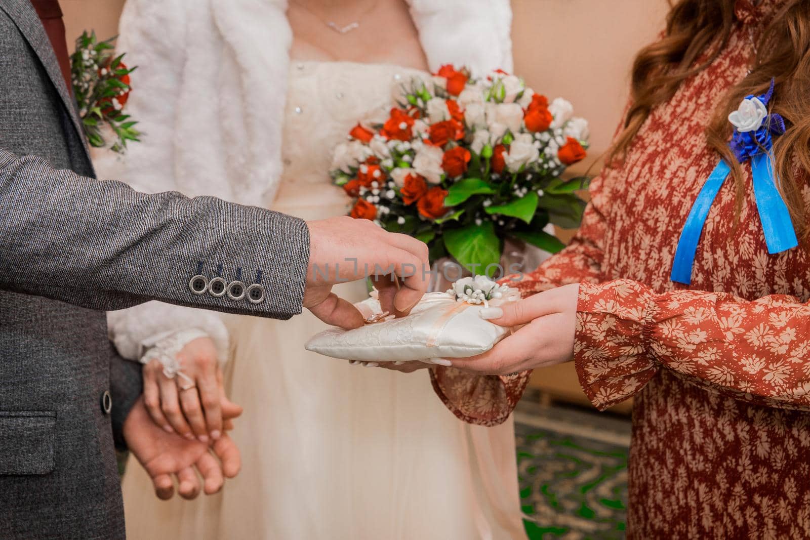 Witness's hands at wedding give groom marriage rings. Exchange of wedding rings.