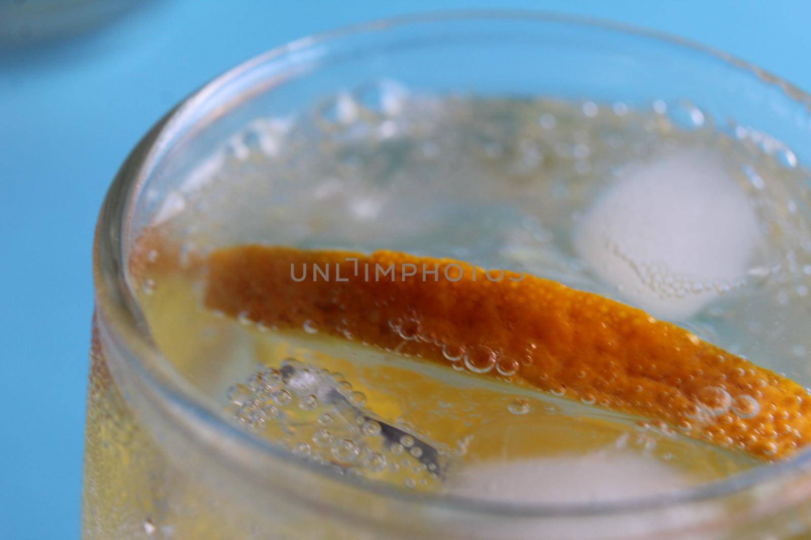 Step-by-step instruction of making lemonade. Step 3. Ready-made fresh lemonade with water ice and fruit close-up view from above on a blue background. Summer refreshing drinks. Heat remedy.
