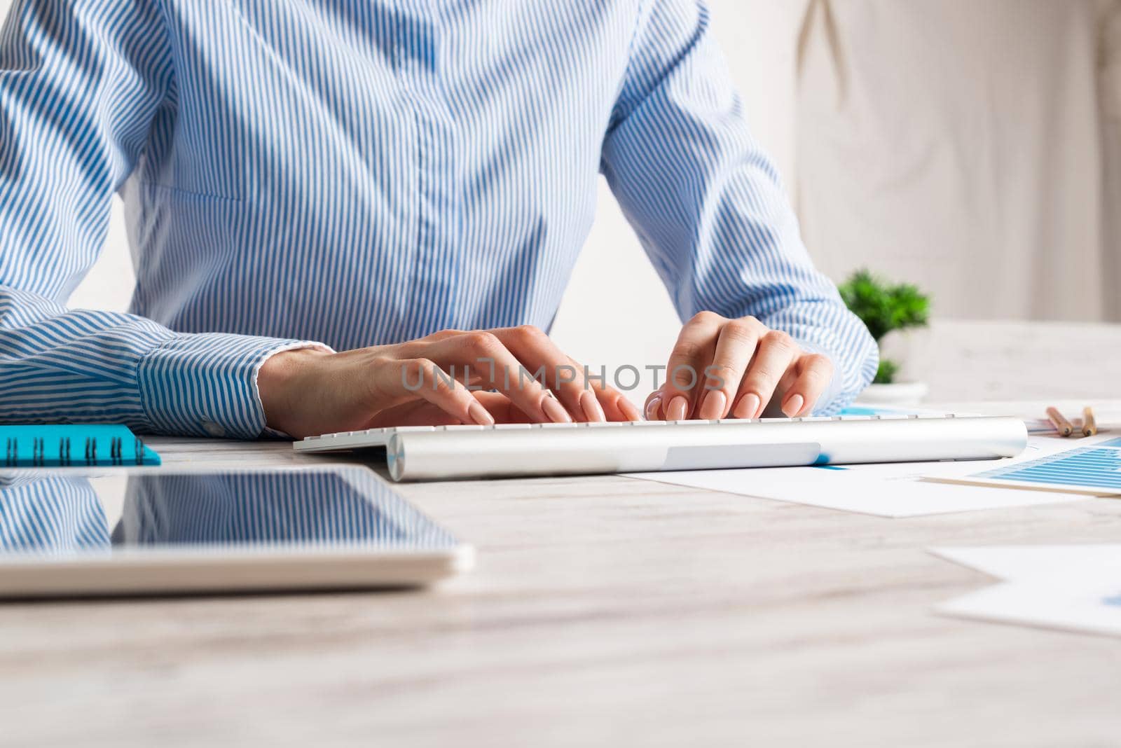 Manager typing on computer keyboard. Close up woman hand with pen. Strategy planning and banking. Corporate office workplace with analyst at wooden desk. Business accounting and management.