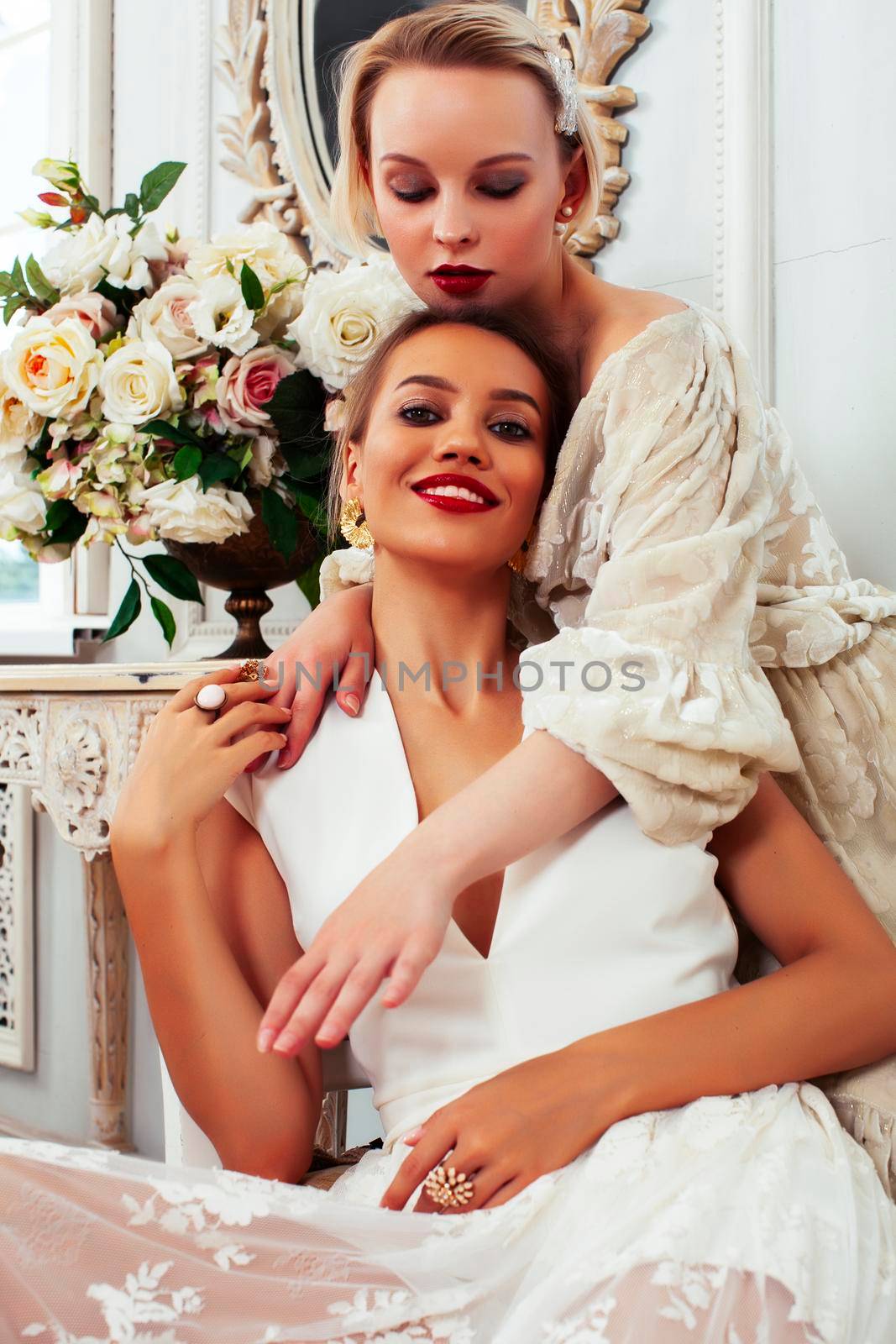 two young pretty lady in white lace fashion style dress posing in rich interior of royal hotel room, luxury lifestyle people concept, bride on wedding day closeup