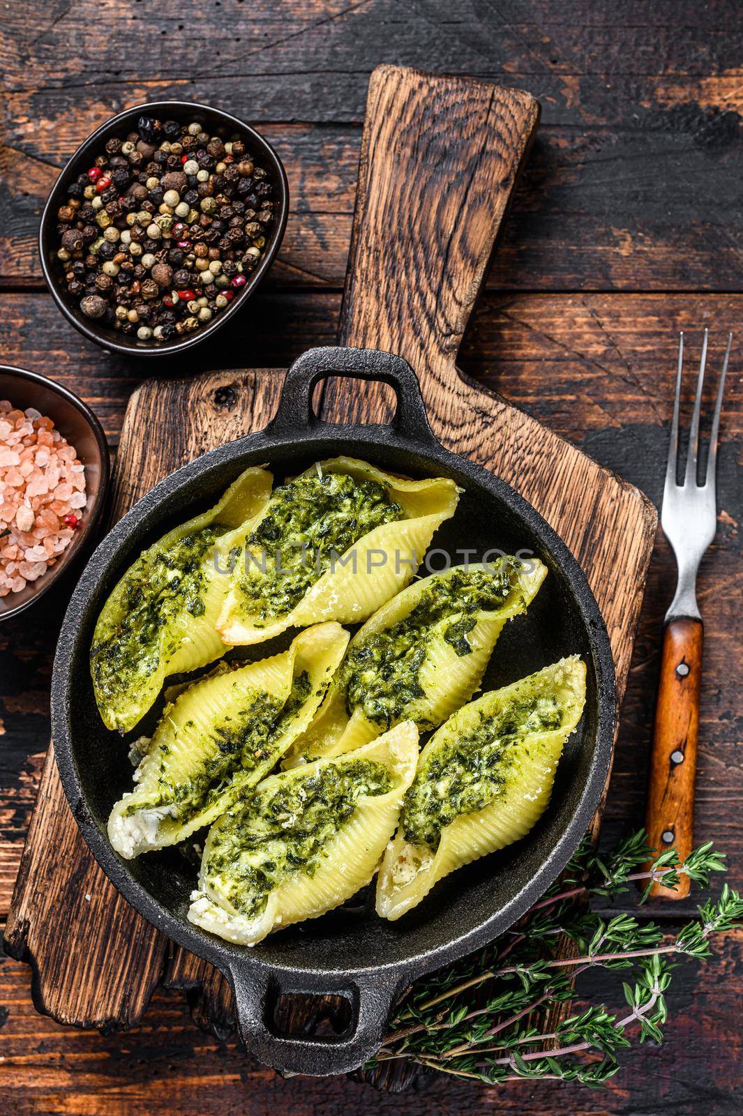 Jumbo shells italian pasta Conchiglioni konkiloni stuffed with beef meat and spinach. Dark Wooden background. Top view by Composter