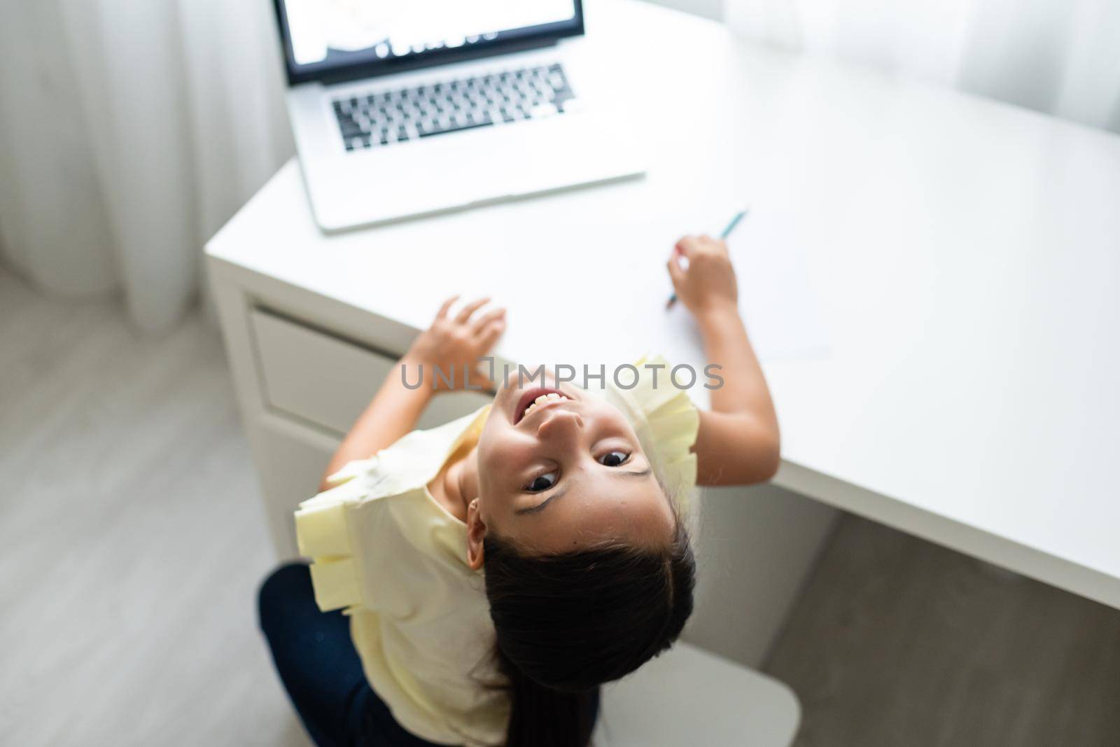cheerful young little girl children using laptop computer, studying through online e-learning system by Andelov13