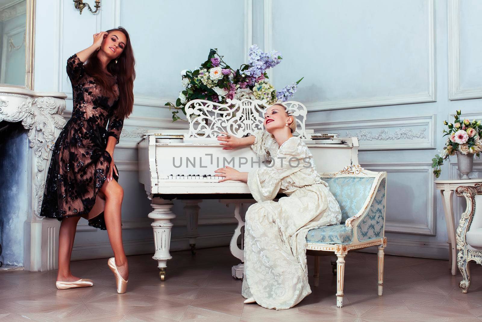 young pretty brunette ballet dancer at piano with blond woman in luxury royal interior, lifestyle rich people concept closeup