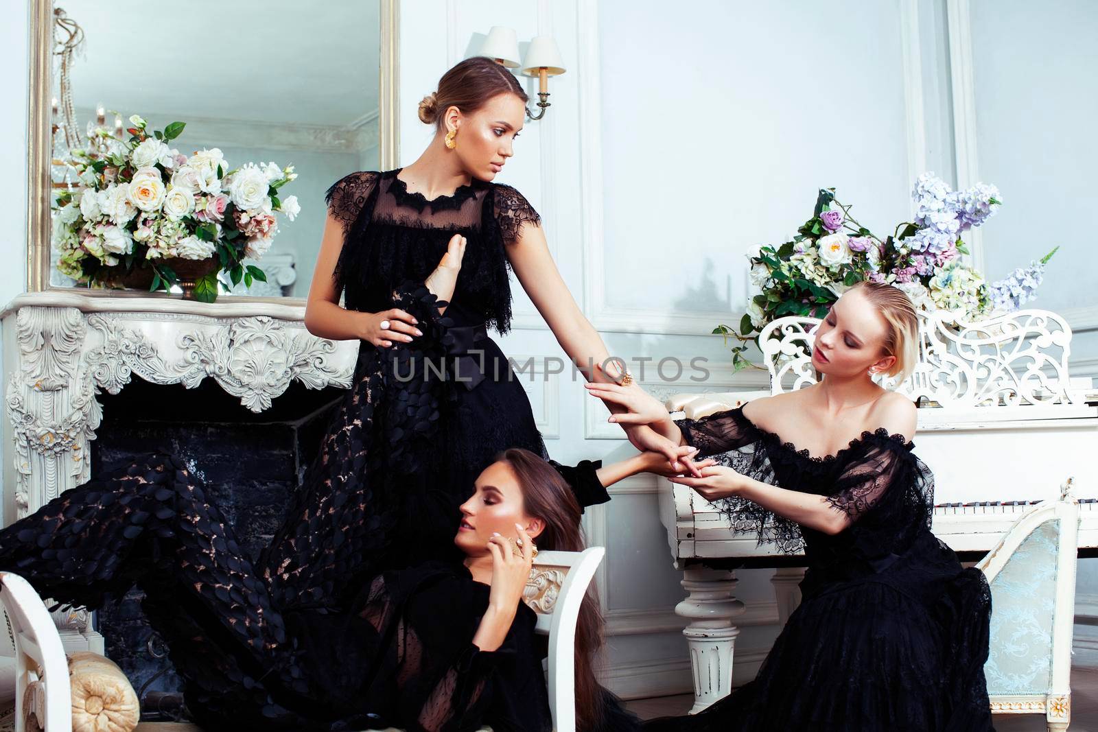 tree young pretty lady in black lace fashion style dress posing in rich interior of royal hotel room, luxury lifestyle people concept closeup