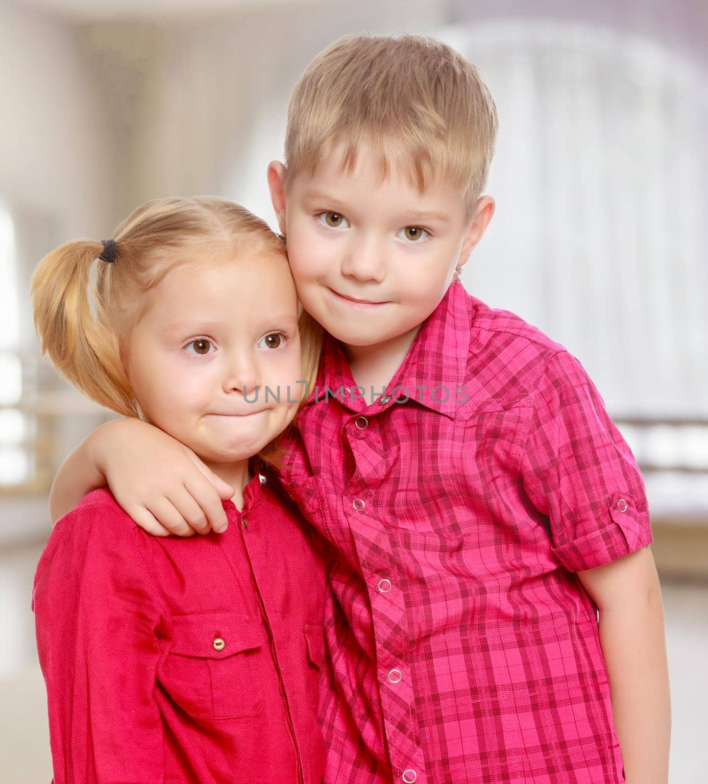 Little brother and sister cute hug.The concept of pre-school education of the child among their peers . in gaming room with a large arched window.