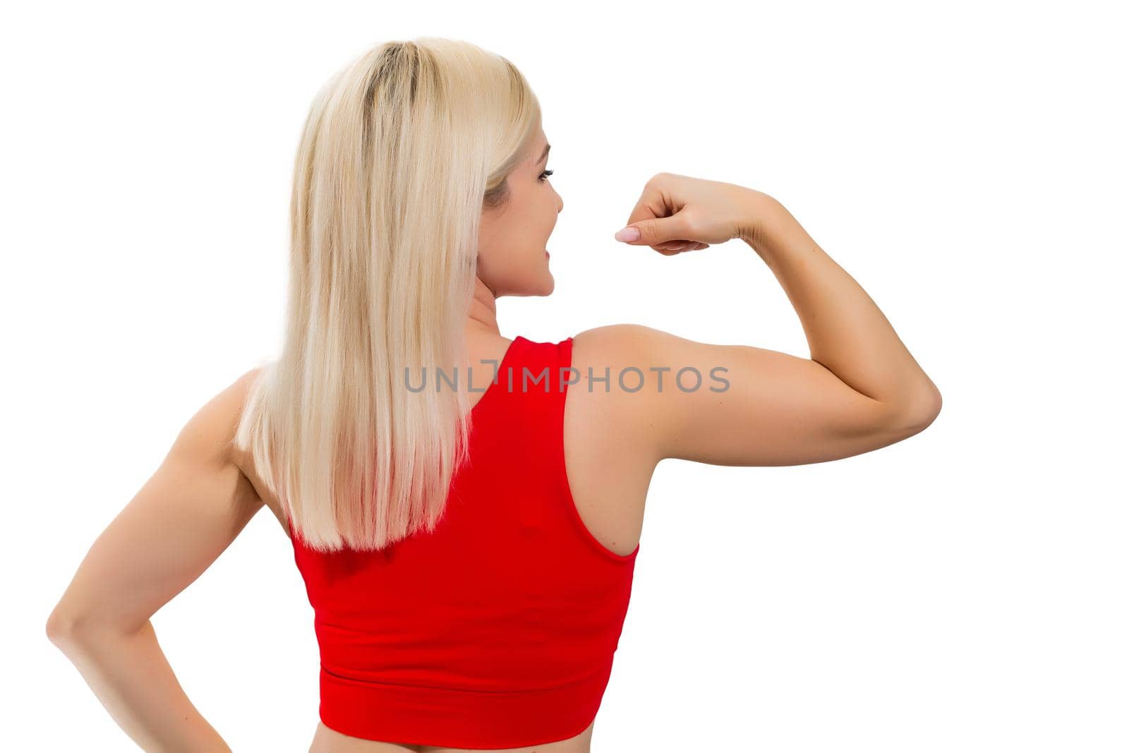 Athletic woman pumping up muscles on gray background