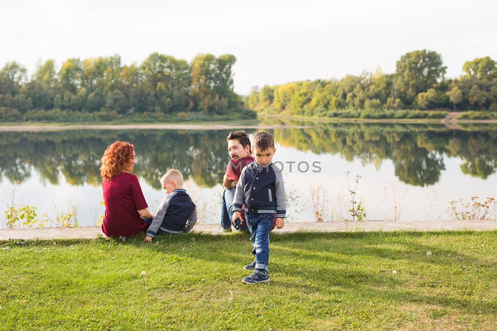 Children, parenthood and nature concept - Big family lying on the grass.