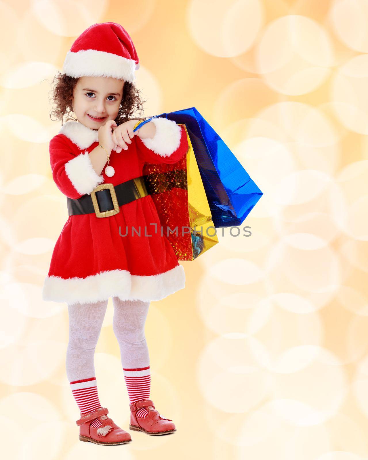 Little girl in costume of Santa Claus with colorful packages by kolesnikov_studio