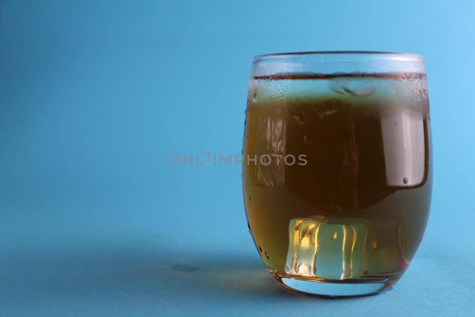 glass of apple juice on a blue background with a place for text and with a copypispe. Summer refreshing cold soft drinks. The field of juice. Natural products by Shoba