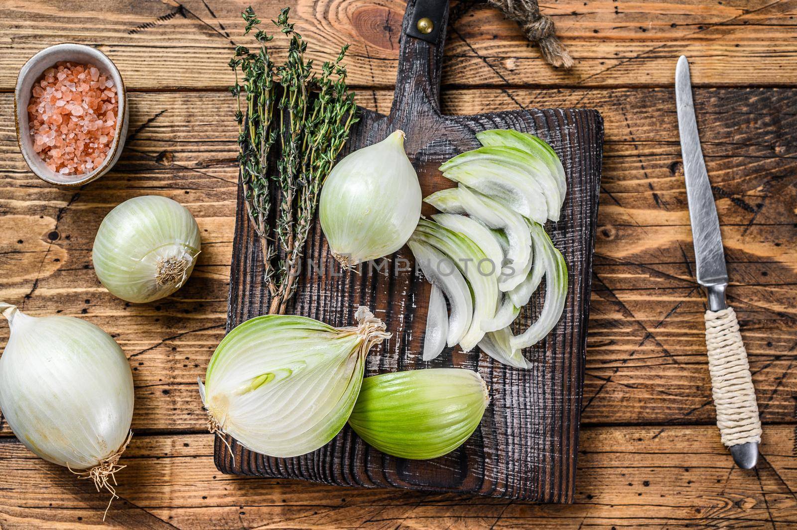 Sliced Raw white onion on a wooden cutting board. Wooden background. Top view by Composter