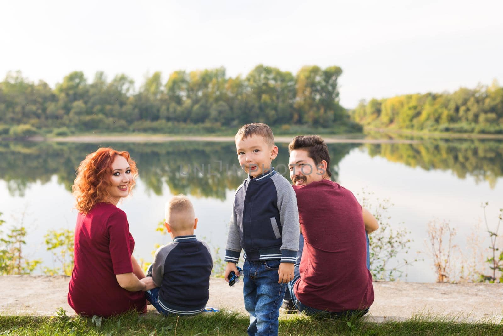 Children, parenthood and nature concept - Big family lying on the grass.