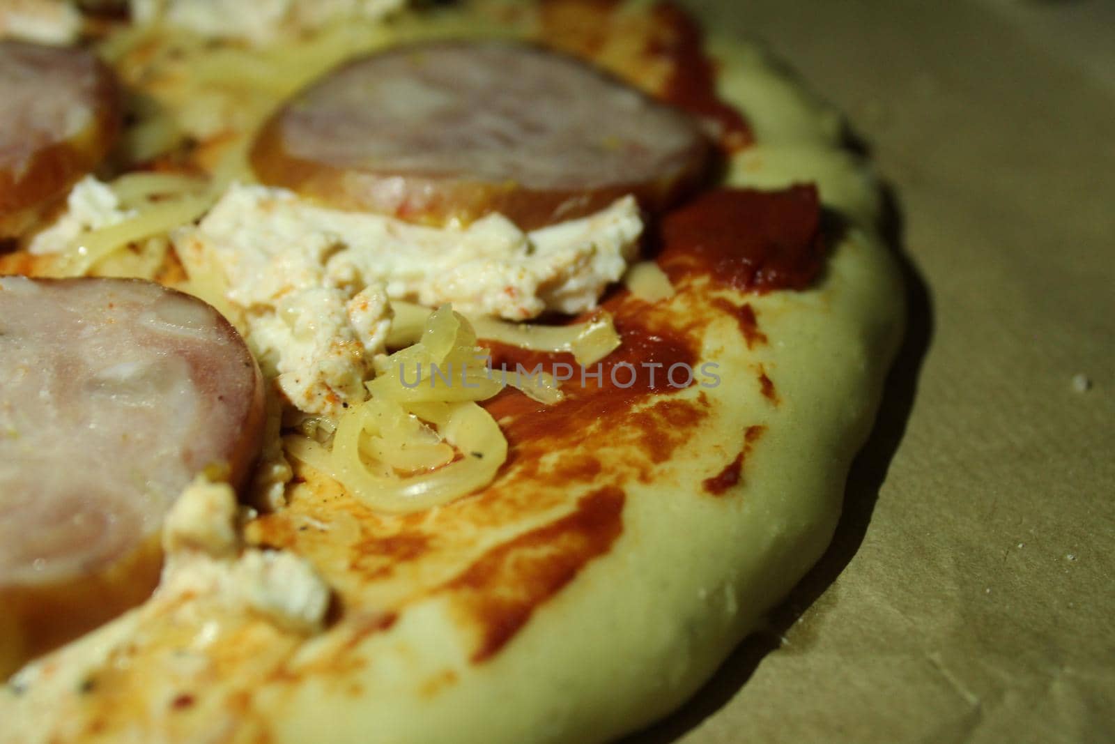 homemade round pizza with ham sausage and cheese close-up. Cooking at home, home meals.