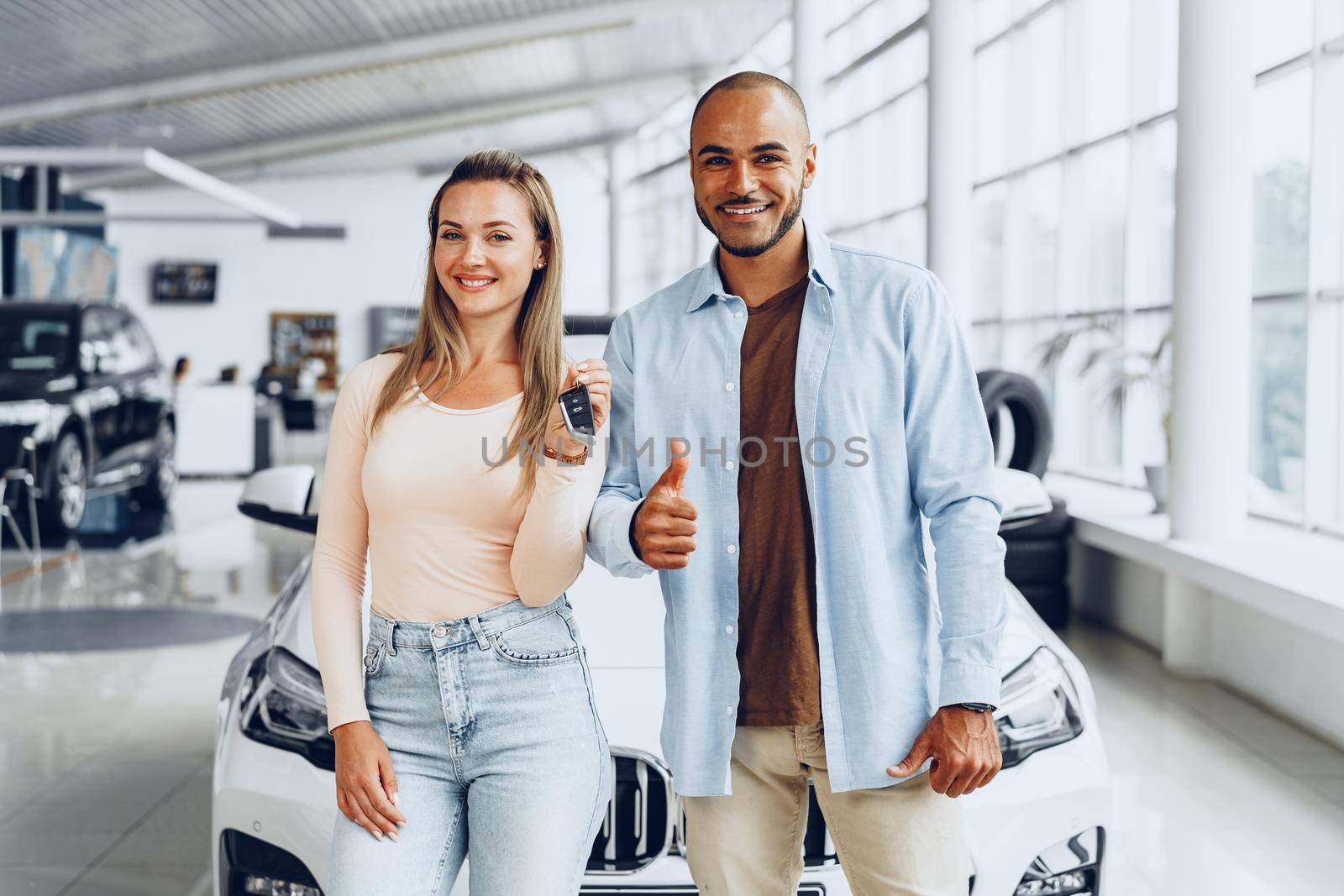 Happy excited couple or family buying a new car and showing keys
