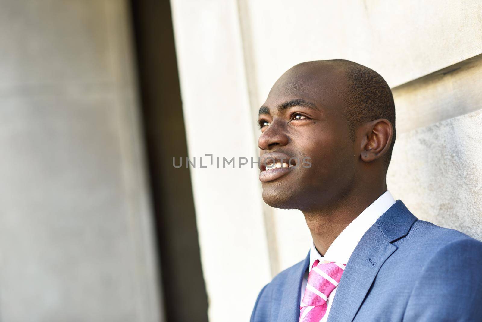 Portrait of handsome black man wearing suit in urban background