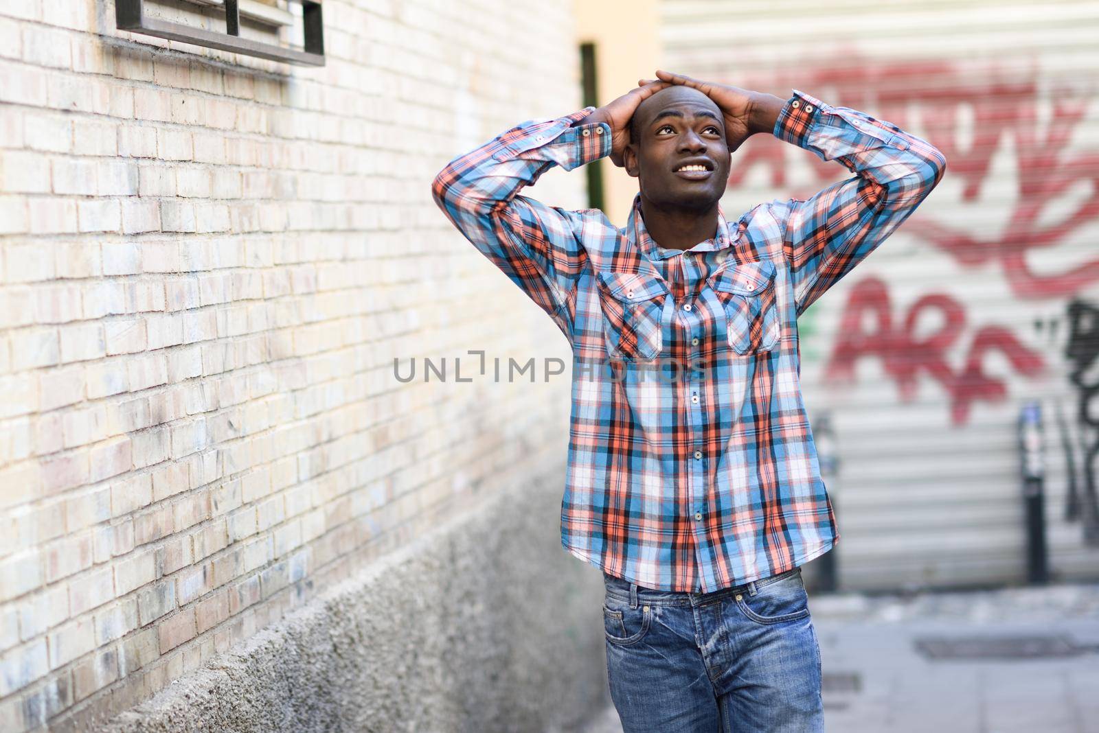 Portrait of black man very happy, smiling in urban background
