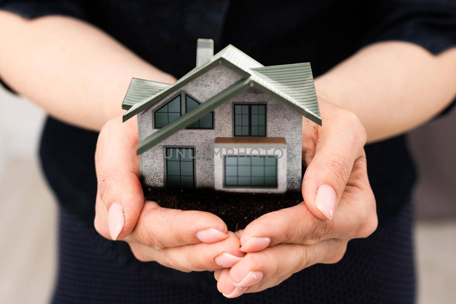 woman hands holding paper house, model.