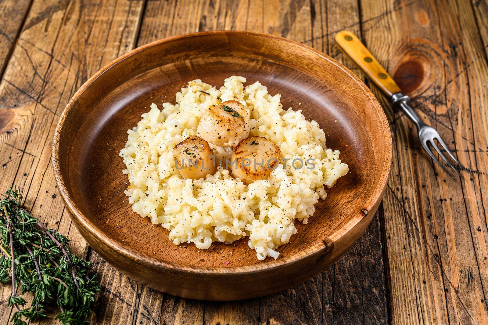 Italian Risotto with Scallops in a pan. wooden background. Top view by Composter