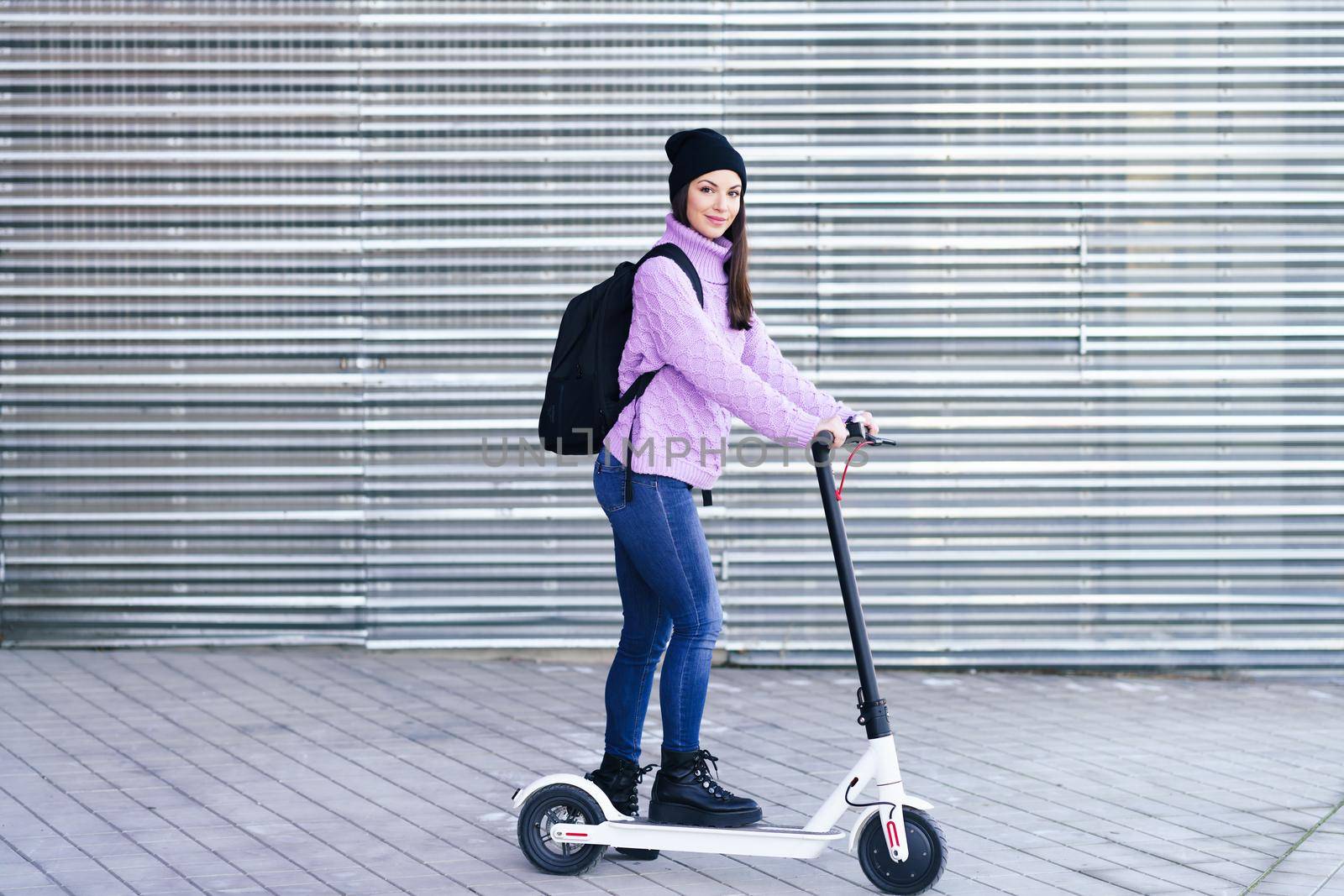 Young woman in her twenties riding an electric scooter. Lifestyle concept.