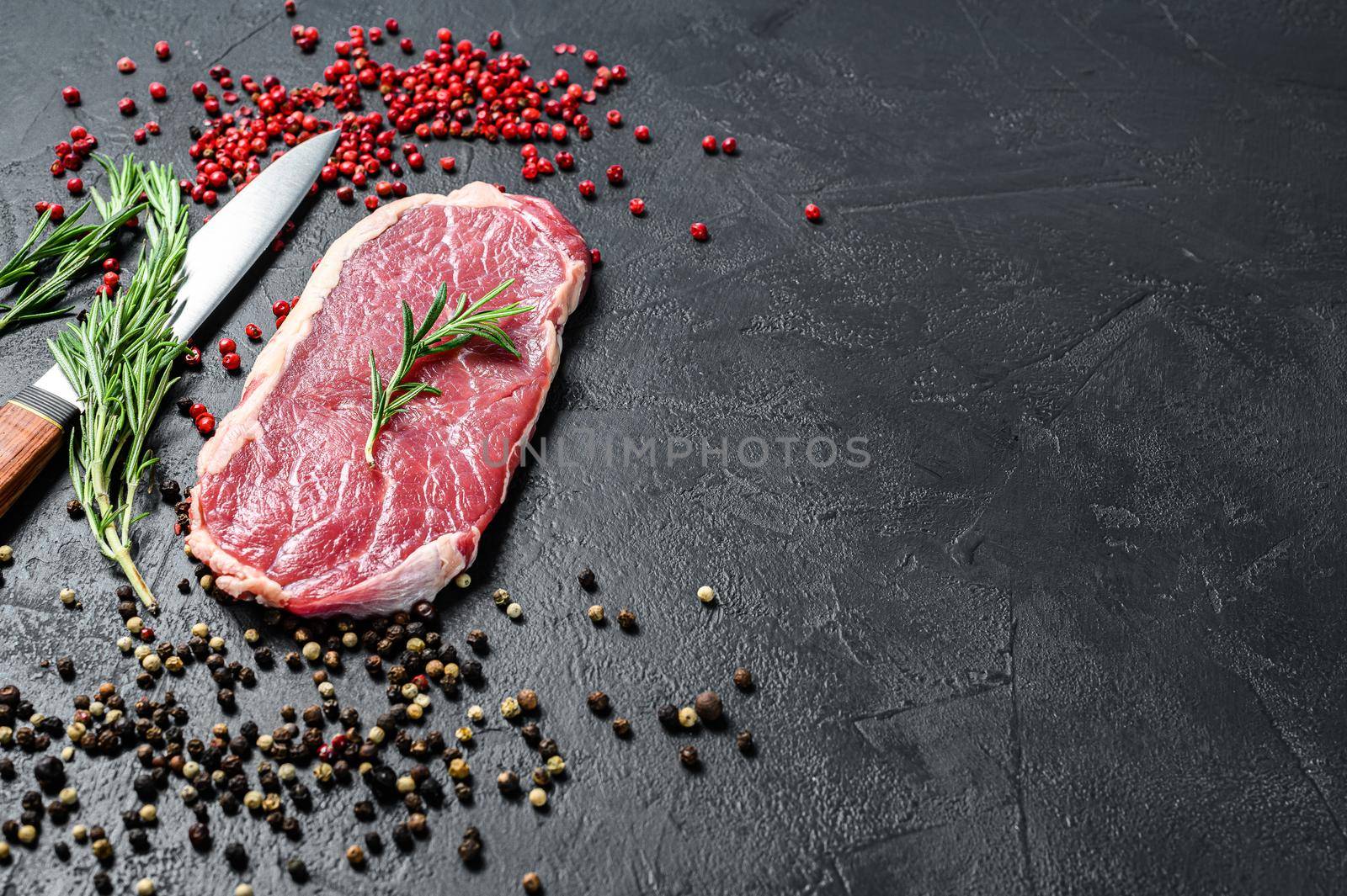 Striploin, strip loin steak or new York. Raw beef. Black background. Top view. Copy space by Composter