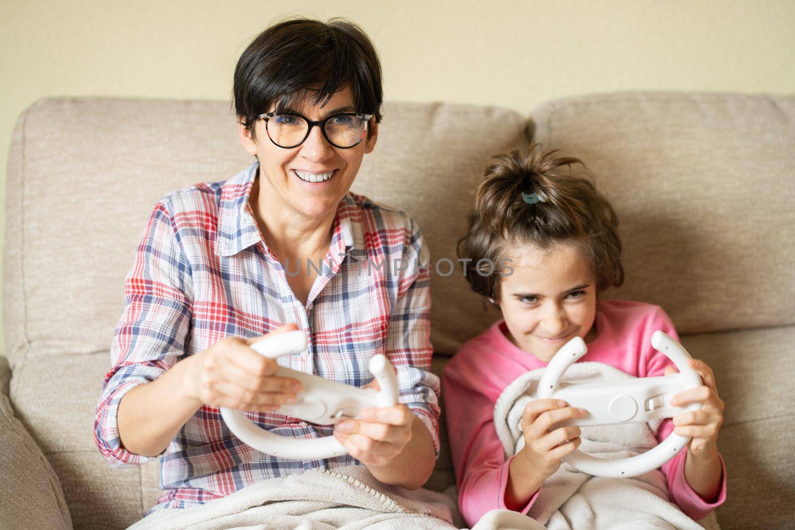 Mother and daughter playing video games at home with a wireless console
