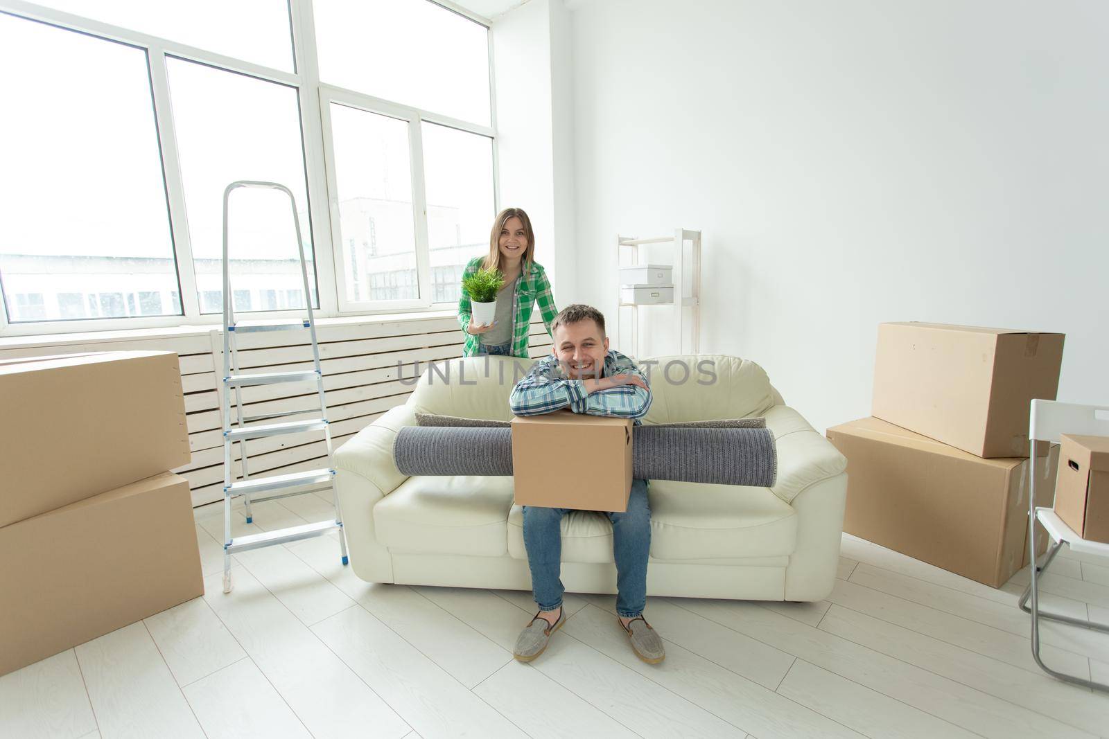 Relocation, real estate and moving concept - Young cheerful couple moving into their new home by Satura86
