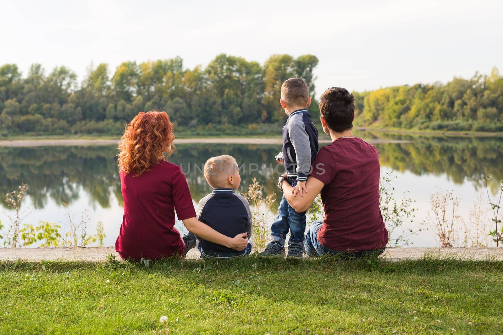 Children, parenthood and nature concept - Big family sitting on the grass by Satura86