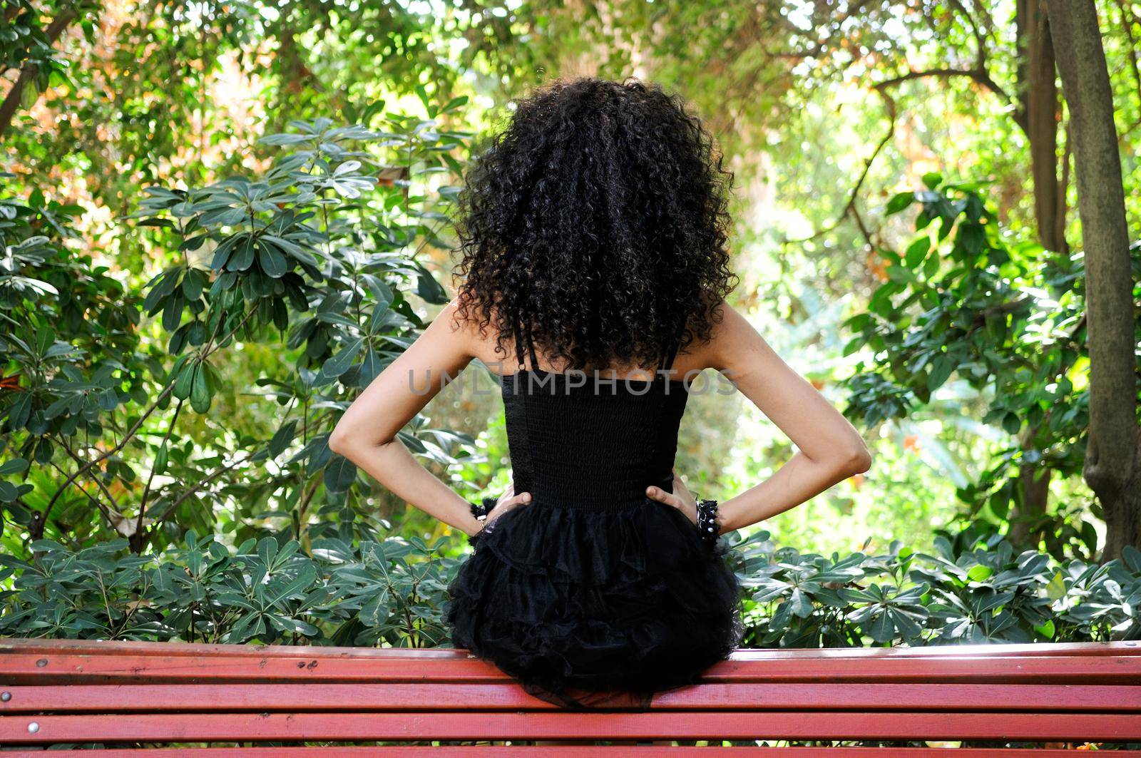 Portrait of a young black woman, model of fashion in a garden