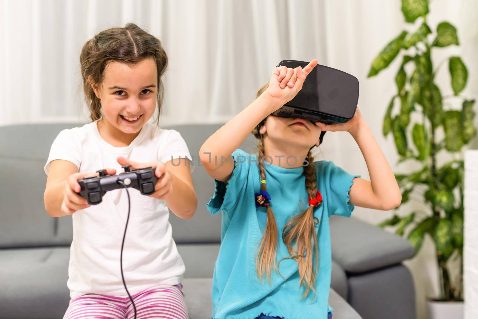 two little girls using glasses of virtual reality headset. concept of modern technologies