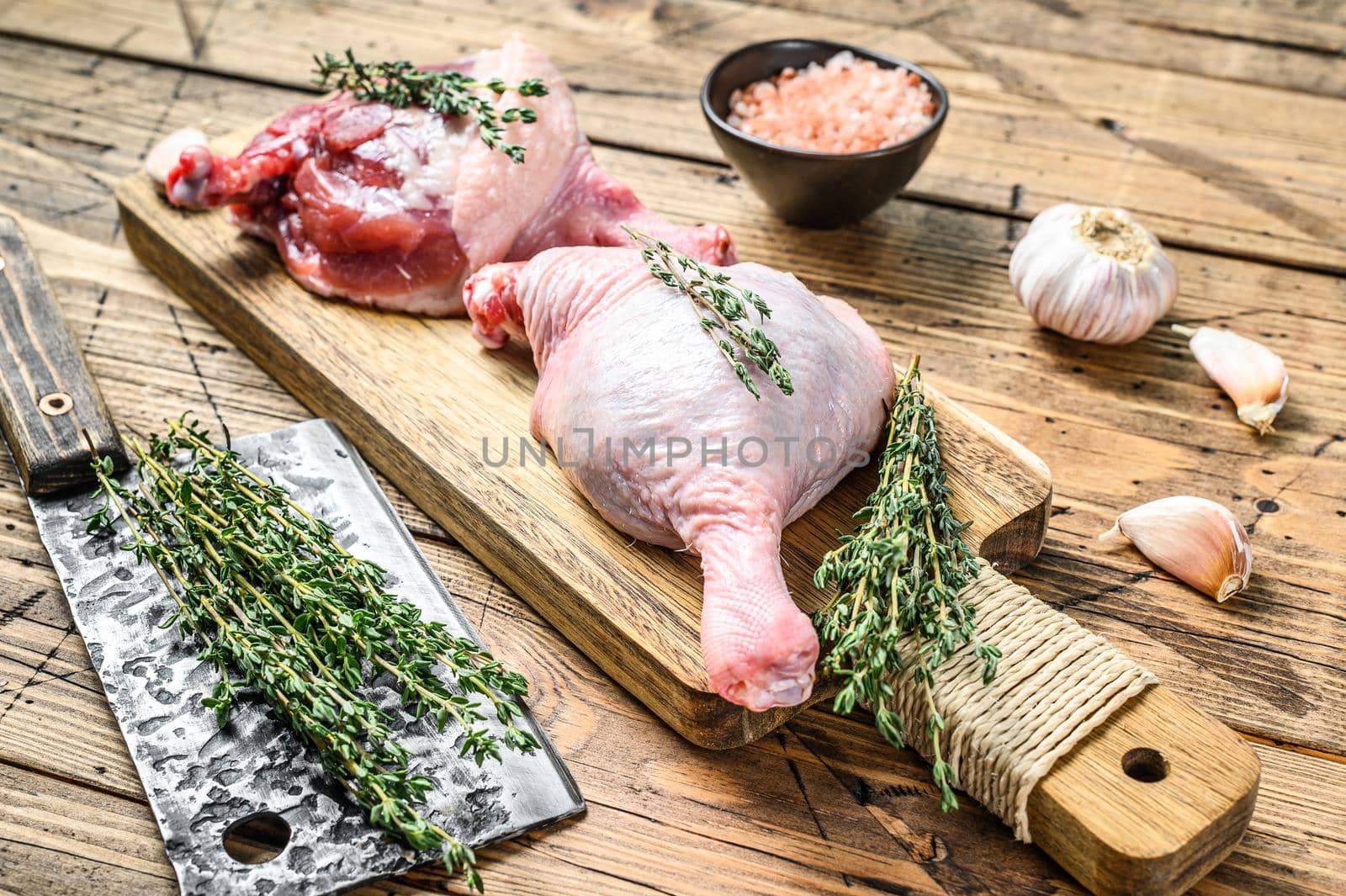 Duck legs on cutting board, Raw meat. Wooden background. Top view.