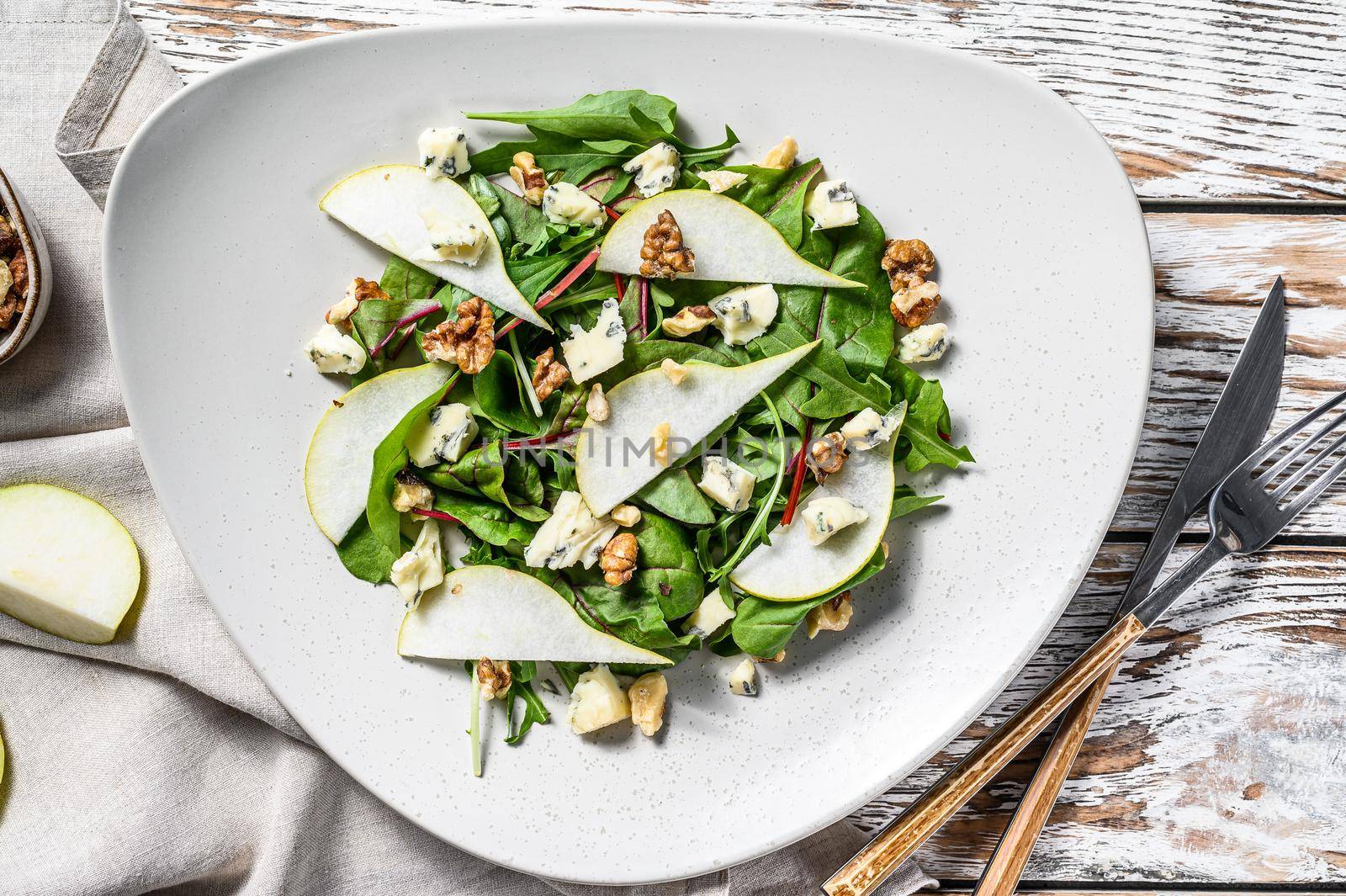 Salad with blue cheese, pears, nuts, chard and arugula. White background. Top view by Composter